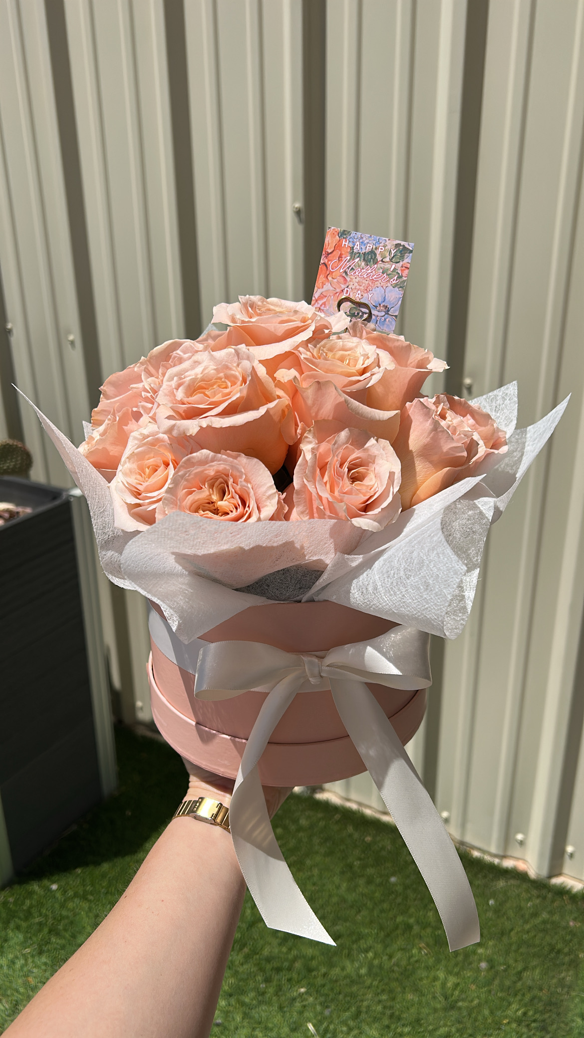Peach roses arranged in a round blush keepsake box
