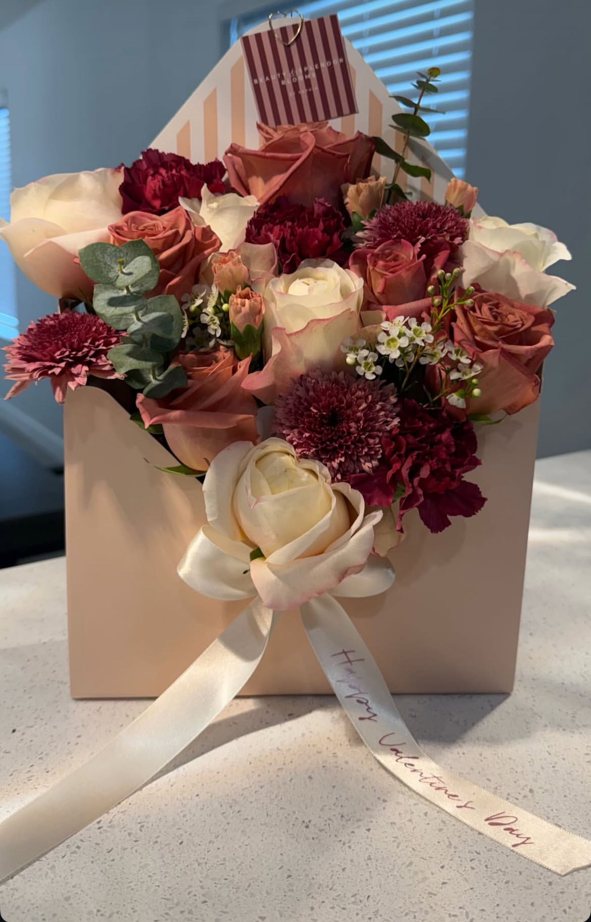 Dusty rose and burgundy arrangement in the signature striped envelope box
